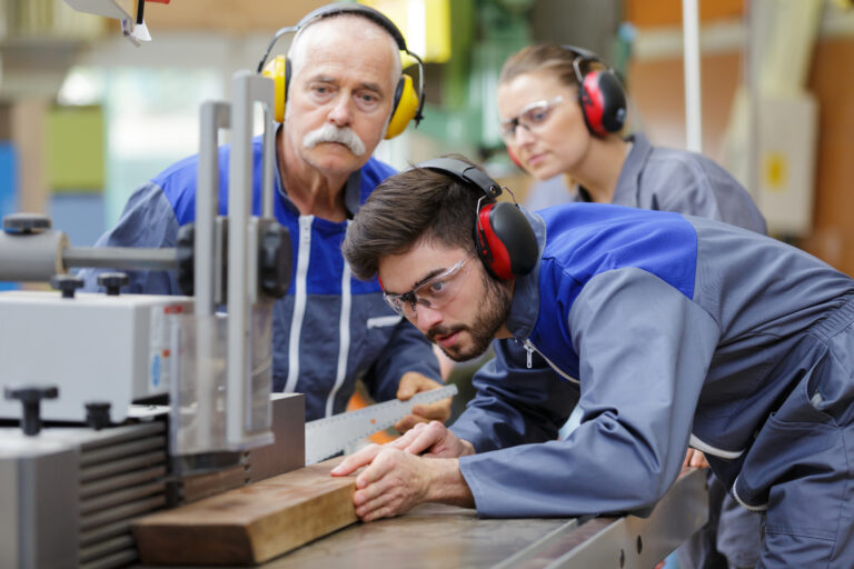 carpenter training female apprentice to use plane