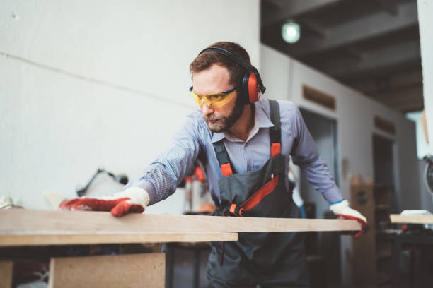 Man with protective eyewear cutting a plank