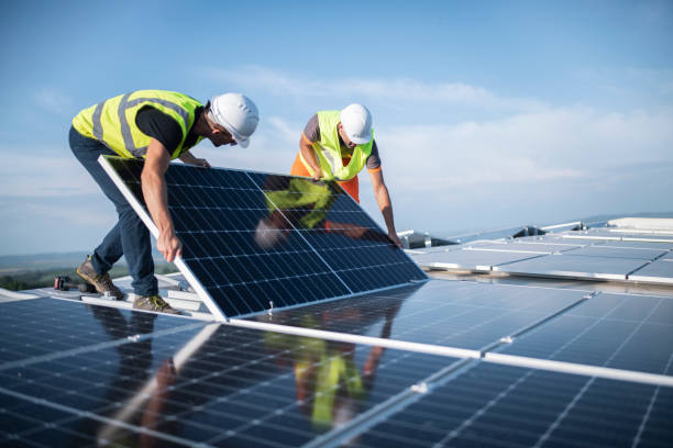 Team of two engineers installing solar panels on roof