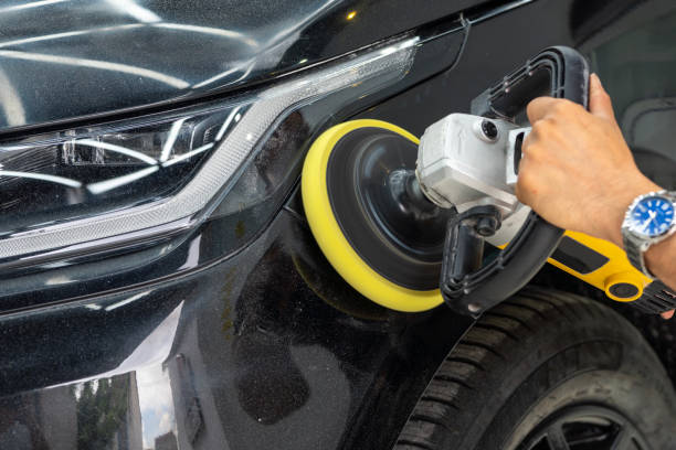 Car service worker polishes a car details