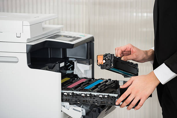 Midsection of young businessman fixing cartridge in printer machine at office